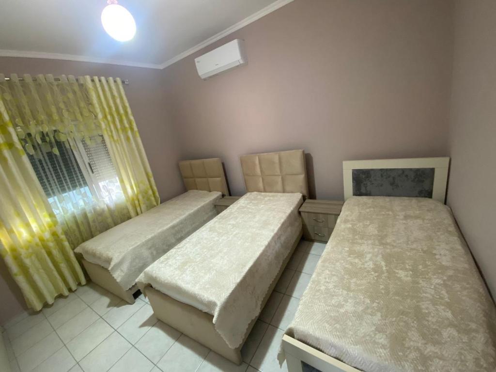 ベラトにあるVila Besimのベッドルーム1室(ベッド2台、窓付)