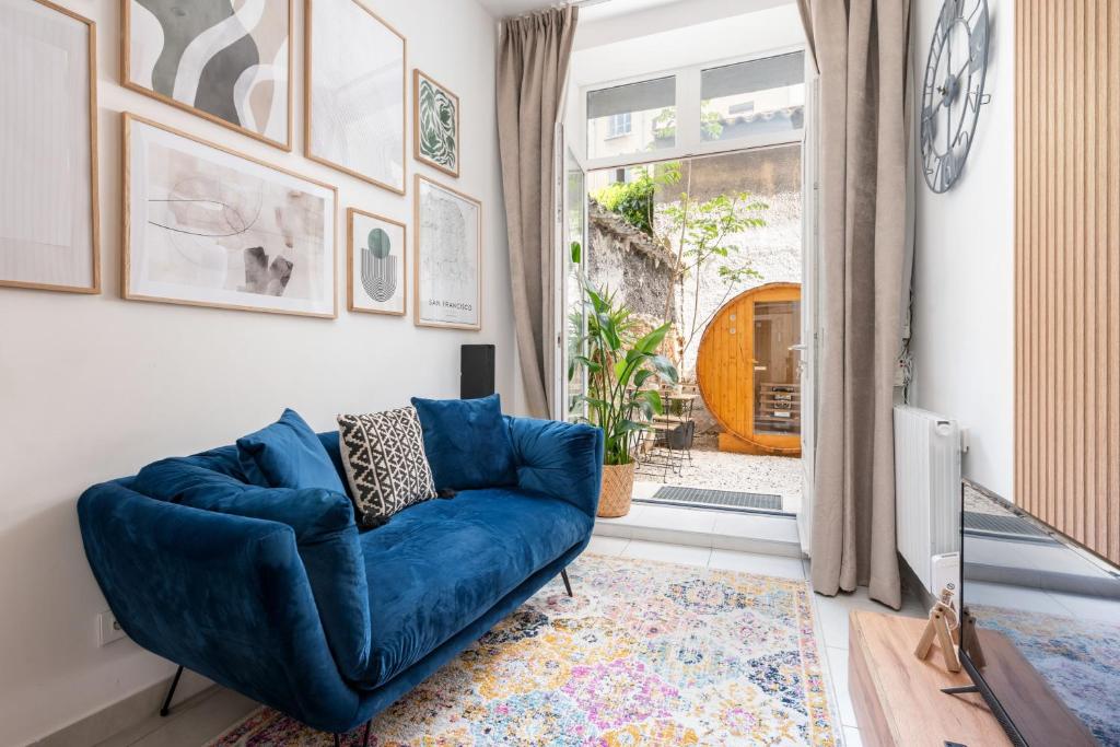 a blue couch in a living room with a window at Le Cocon Traboule & SPA in Lyon