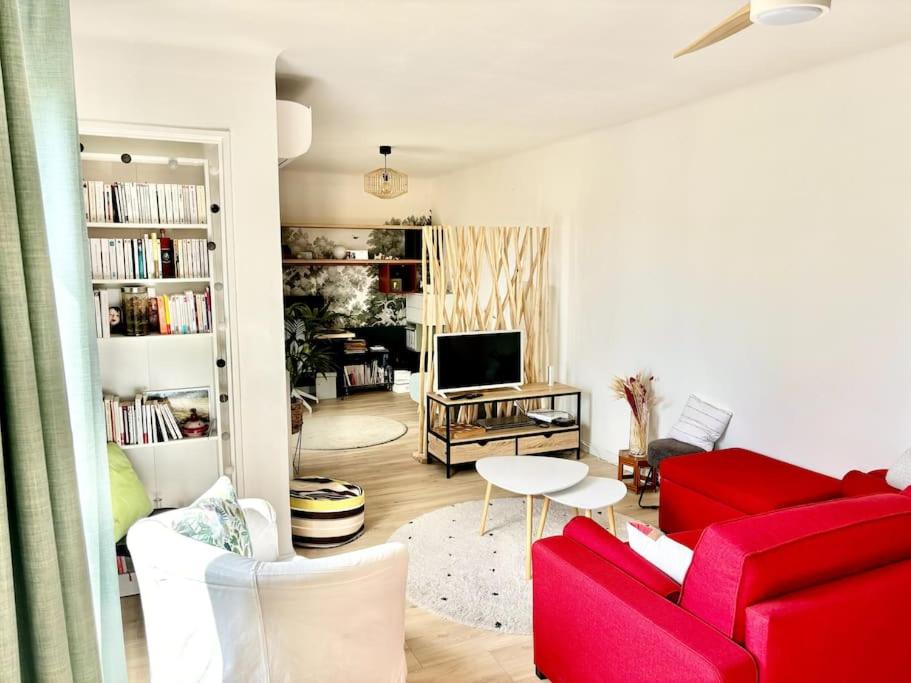 a living room with a red couch and a tv at Beau T3 moderne et lumineux in Aix-en-Provence