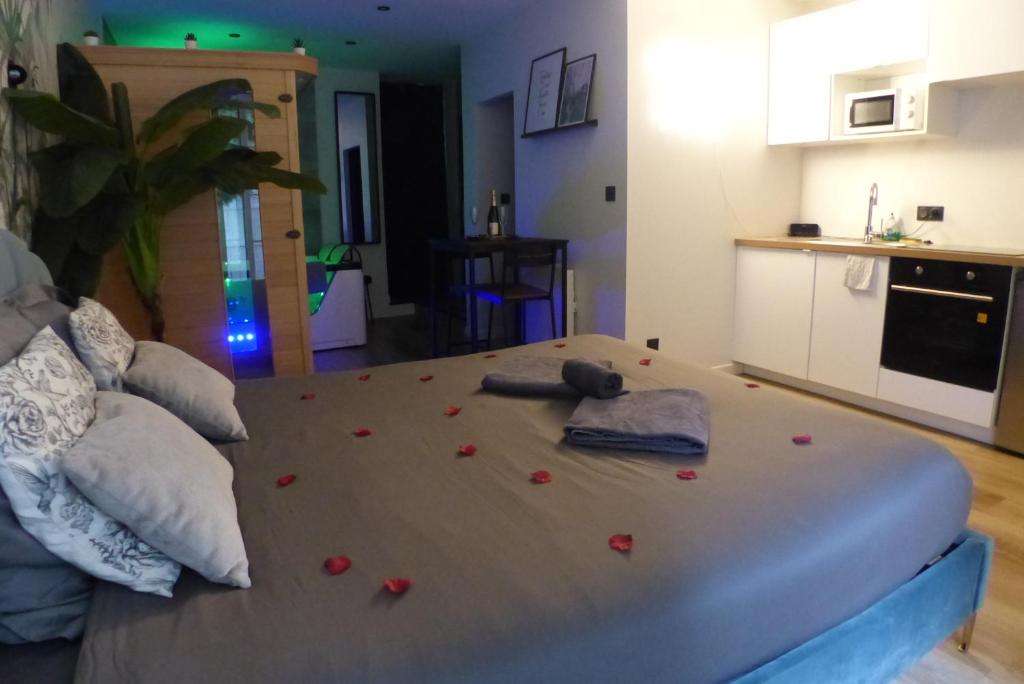 una cama grande con rosas en una habitación en Appartement balnéothérapie et sauna hyper centre, en Nantes