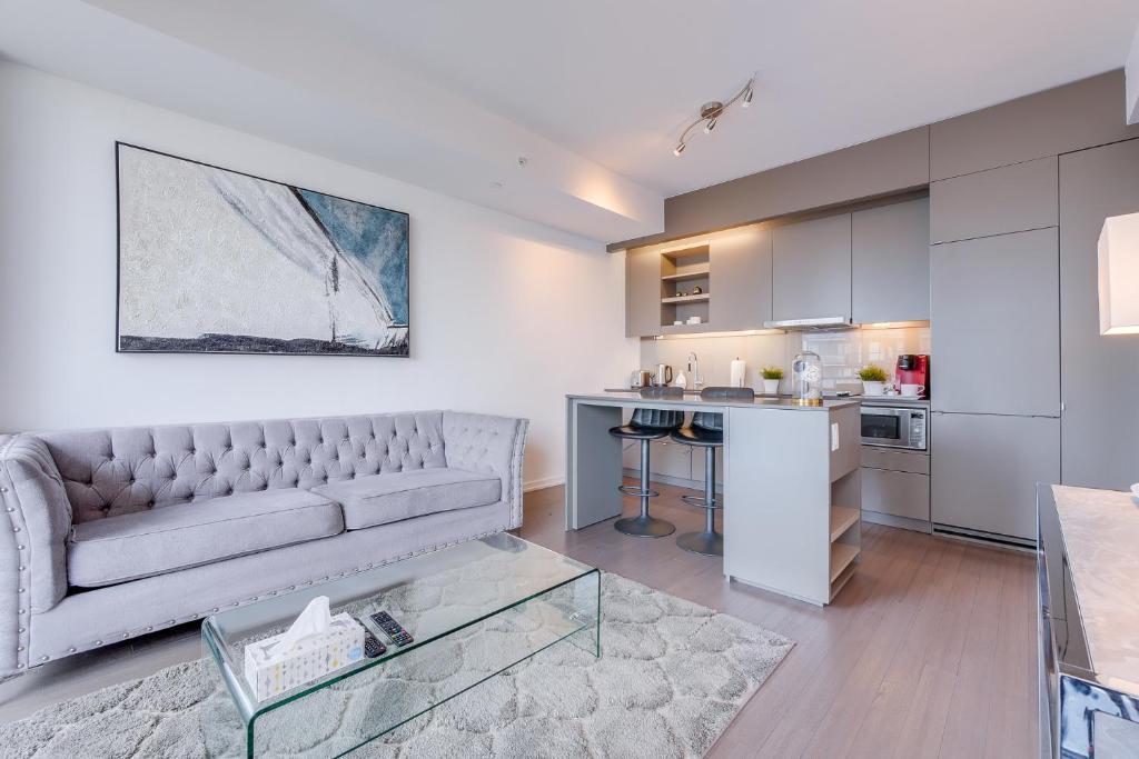 uma sala de estar com um sofá e uma cozinha em 1BR Condo - City View, Near CN Tower & Rogers Center em Toronto