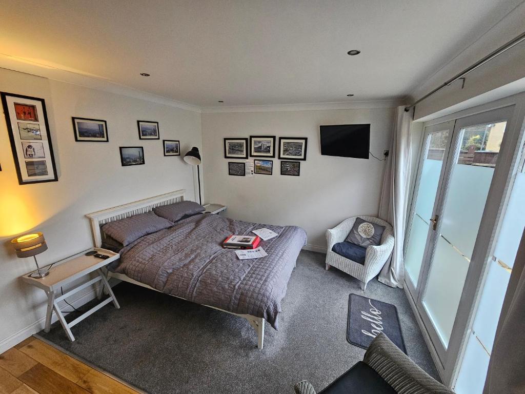 een slaapkamer met een bed en een stoel bij Modern immaculate studio with aircon & parking in Bristol