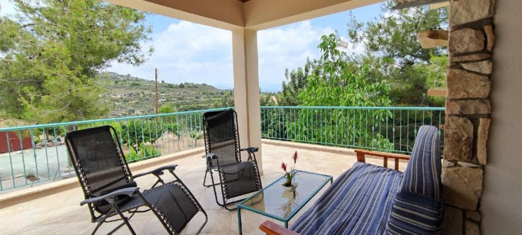 a patio with a glass table and chairs on a balcony at House on a Hill with Stunning Views near Troodos in Silikou