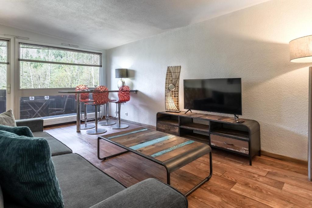 ein Wohnzimmer mit einem Sofa und einem TV in der Unterkunft Appartement Sun Valley in Chamonix-Mont-Blanc