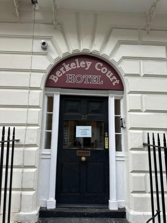 eine Tür zu einem Hotel mit einer schwarzen Tür in der Unterkunft Berkeley Court Hotel in London