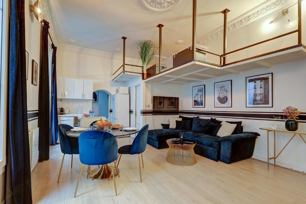 106 - Fabulous studio in Champs Elysees في باريس: غرفة معيشة مع أريكة زرقاء وطاولة