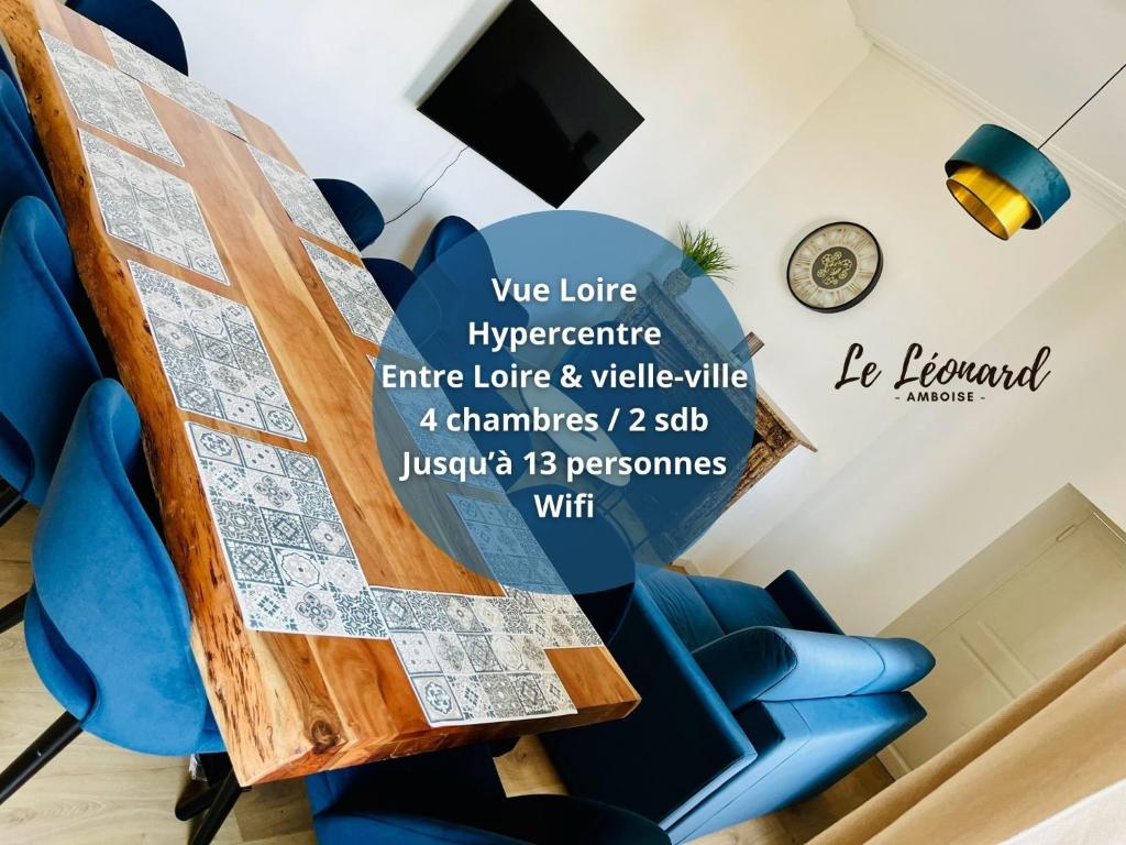 un panneau sur une table à manger avec des chaises bleues dans l'établissement Le Léonard- T5 entre Loire et Château Royal - Manoir de la Concorde, à Amboise