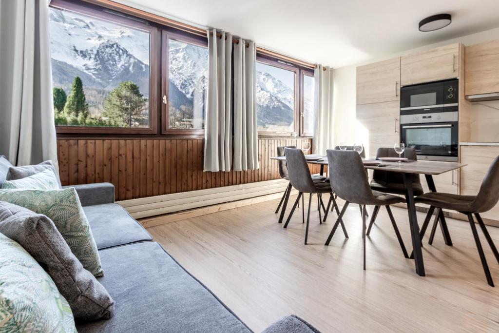 een woonkamer met een tafel en stoelen en bergen bij Sun Valley II in Chamonix-Mont-Blanc