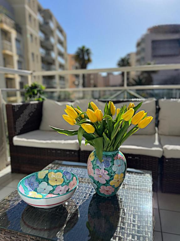 un vase rempli de fleurs jaunes assises sur une table dans l'établissement Nice Riviera, à Nice