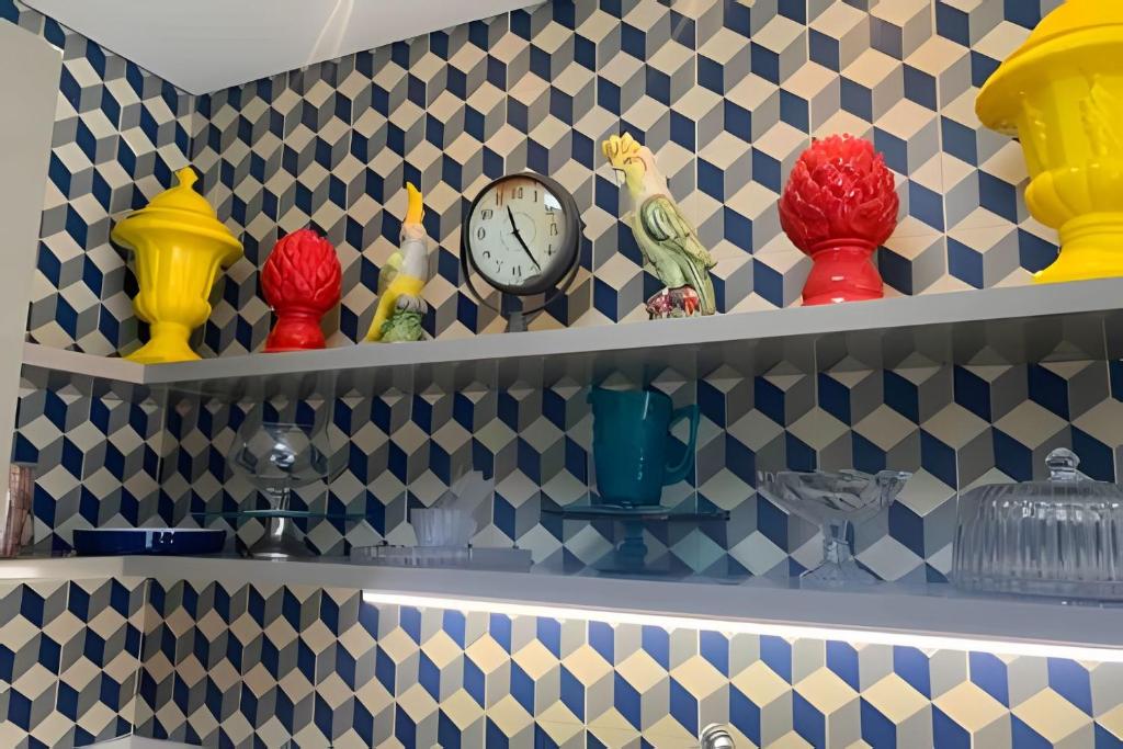 ein Regal mit Uhren und Vasen darauf in der Unterkunft Beira mar alto padrão! in Bertioga