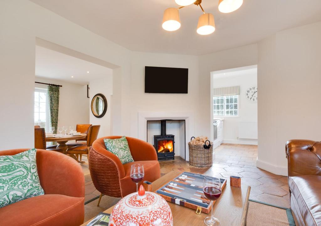 a living room with a couch and a fireplace at Cuckoo Lodge in Wighton
