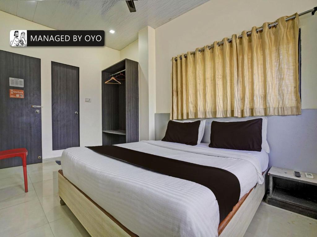 a bedroom with a large bed with a window at Super OYO Kailash Park Near Shivaji International Airport in Mumbai