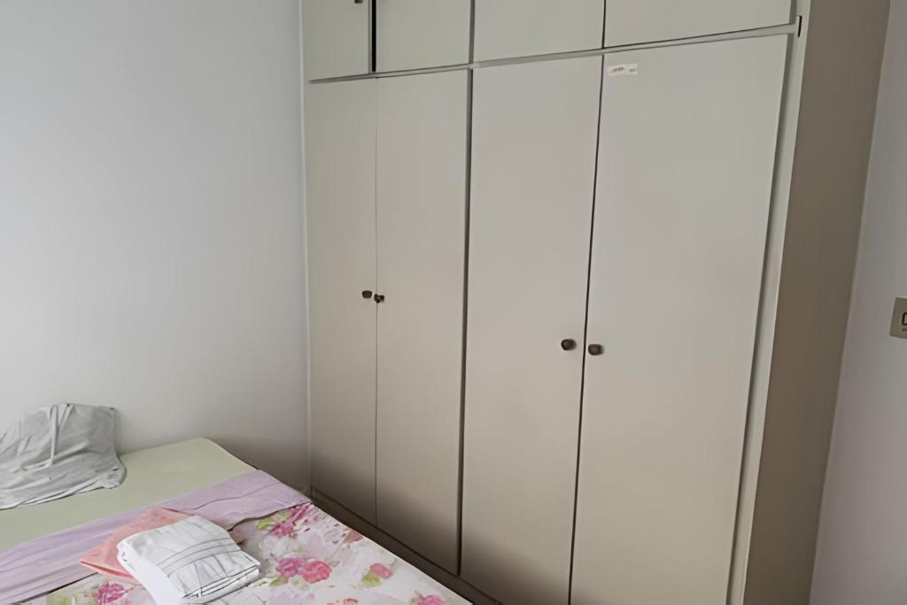 1 dormitorio con armarios blancos y 1 cama en Apê próximo ao eixo monumental, en Brasilia