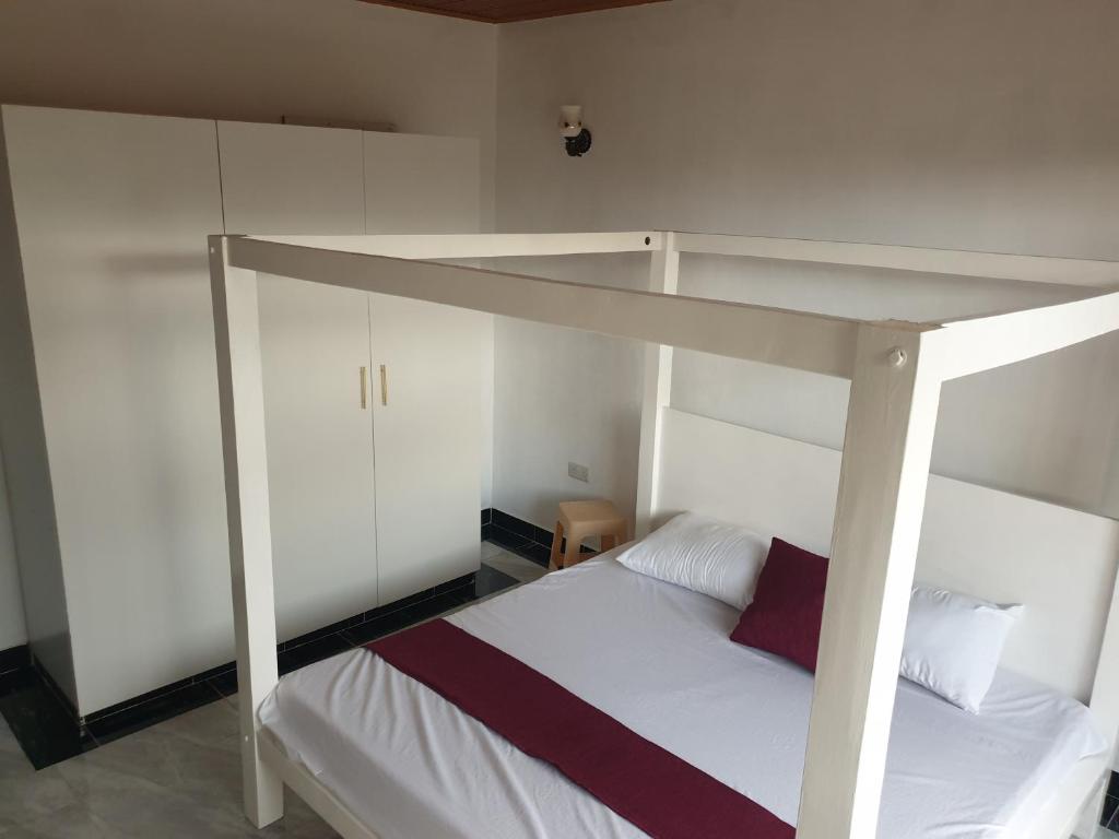 a bedroom with a white bed with a loft bed at RAKA HOLIDAY HOMES in Malindi