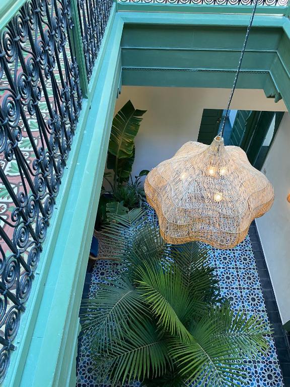 a staircase with a chandelier and a plant at Le Palazzo in Essaouira