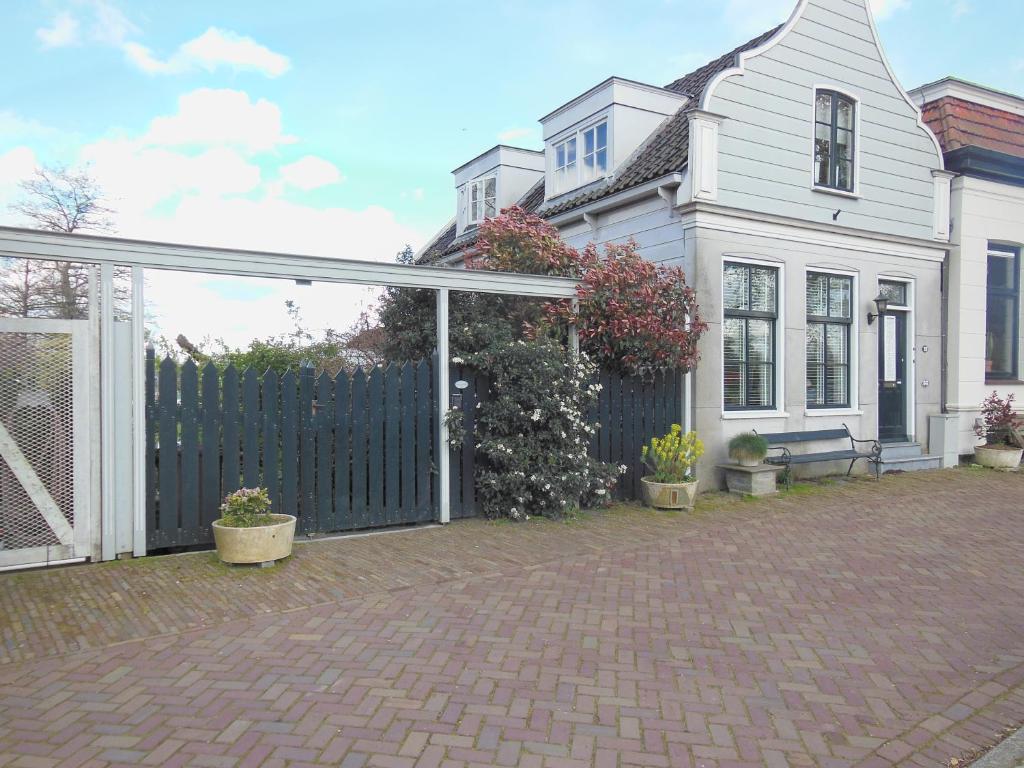 uma casa branca com um portão e uma cerca em Munnik's Hof em Amesterdão
