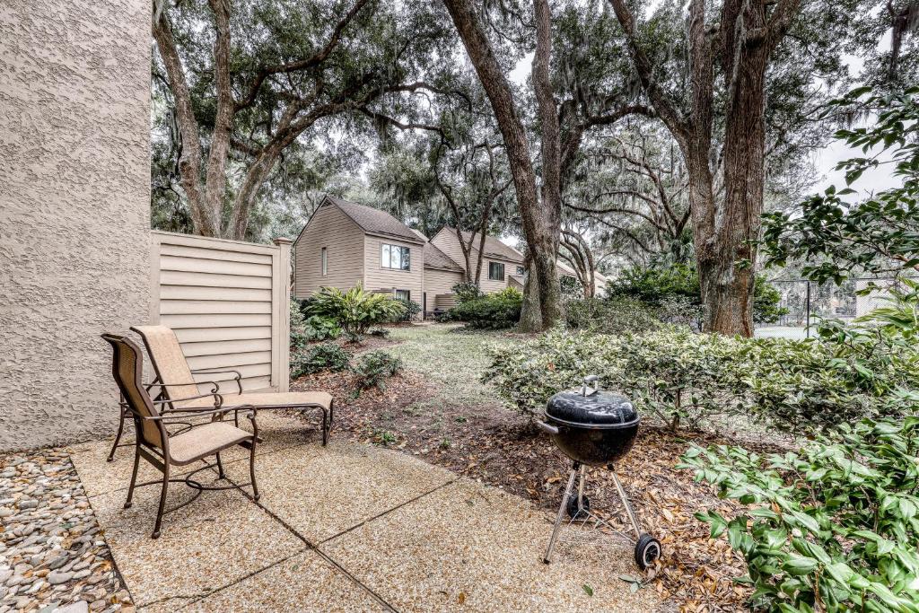 a bbq and a chair and a grill in a yard at Heritage Villas 2307 in Hilton Head Island