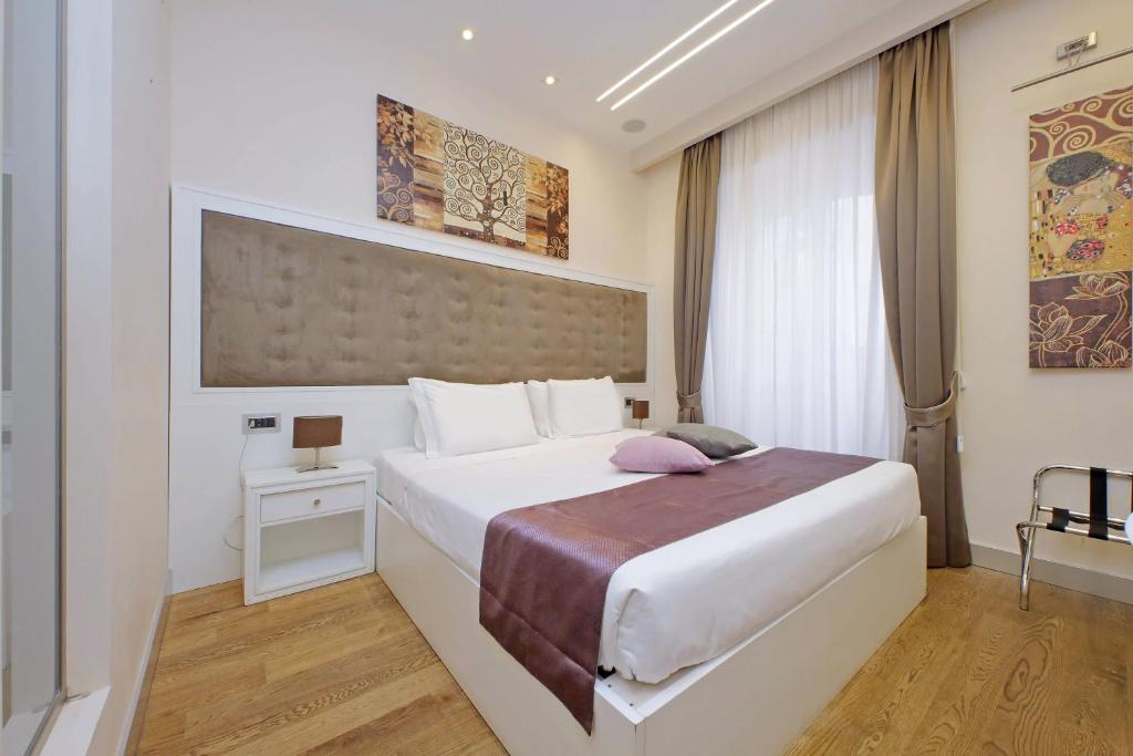 a bedroom with a large white bed and a window at Alla Locanda Malandra in Rome