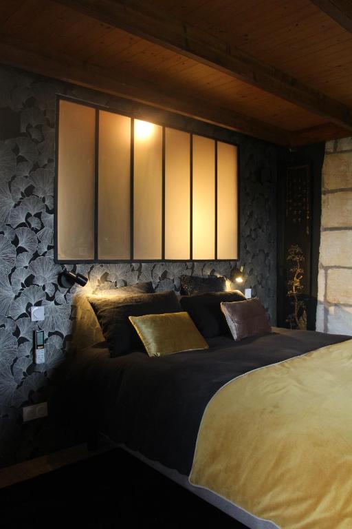 a bedroom with a large bed with lights above it at Domaine de Kiba in Barzan