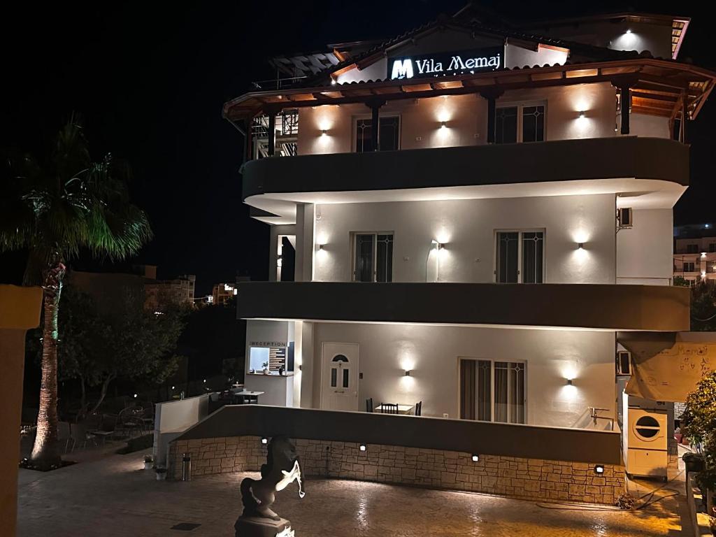a large white building with lights on it at night at Villa Memaj in Ksamil