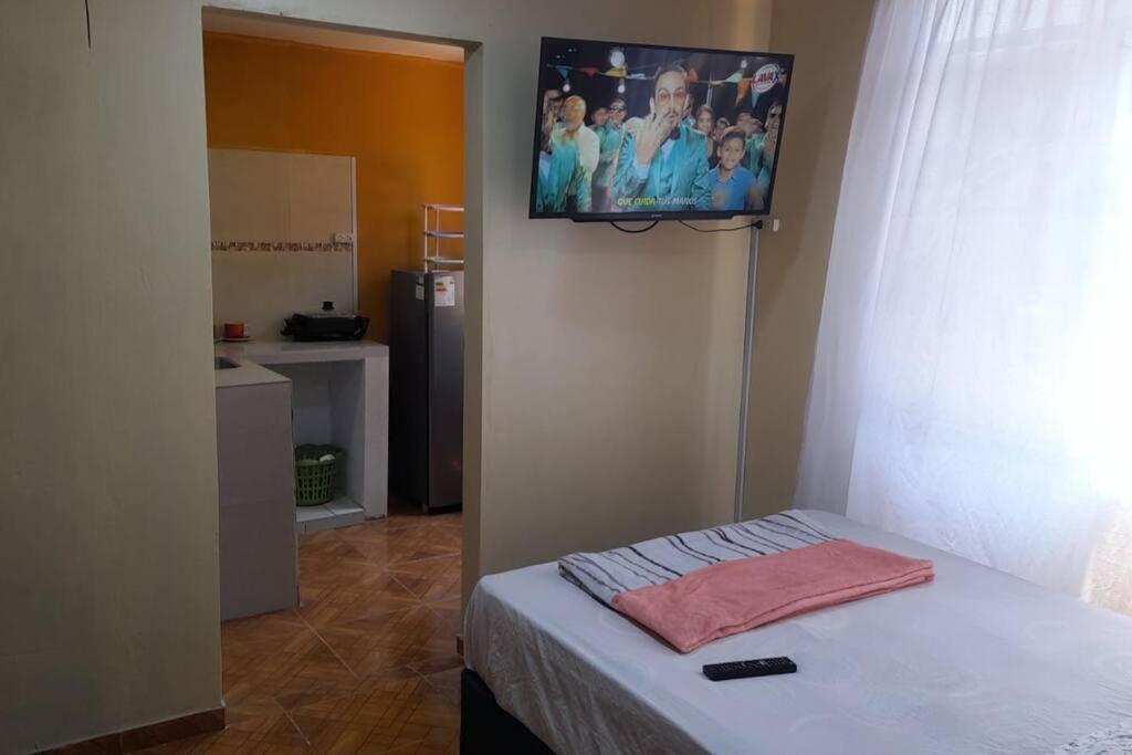 Schlafzimmer mit einem Bett und einem TV an der Wand in der Unterkunft Kely 6 Apartamento 2do Piso in Lima