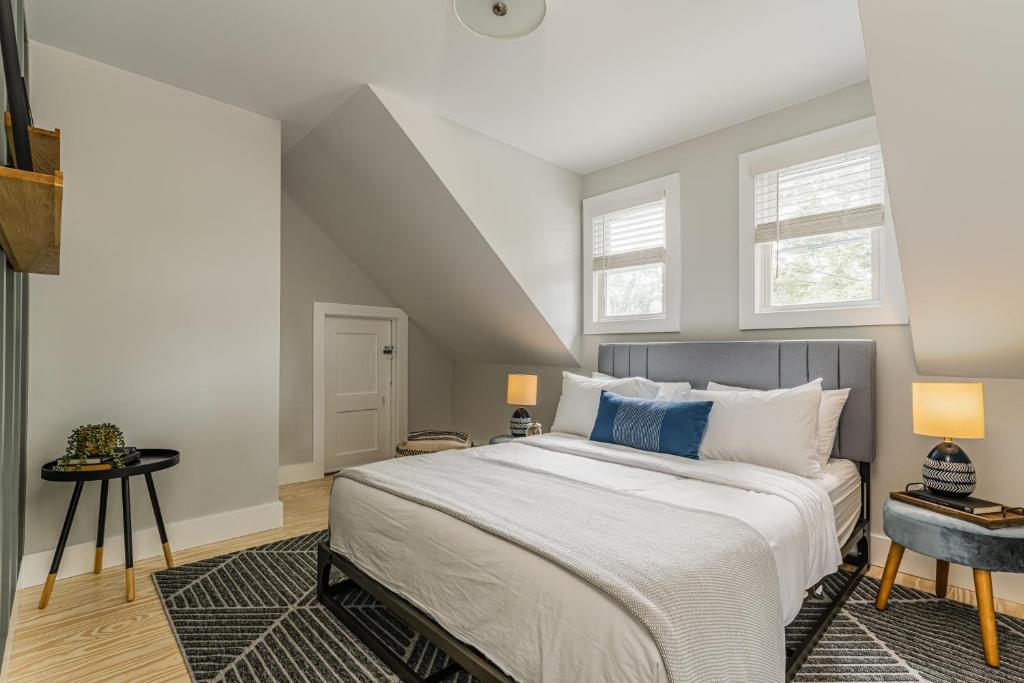 a bedroom with a large bed and two windows at Perch Eagle House: Creek access + mountain views in Boiceville