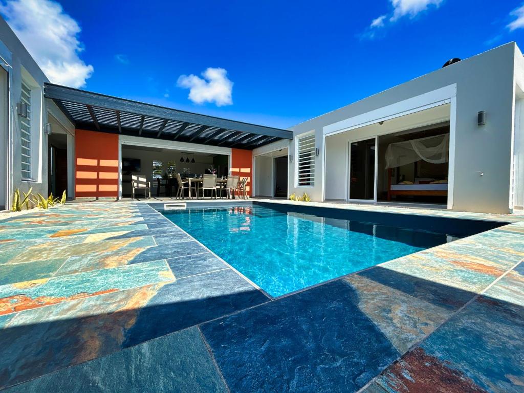 an image of a swimming pool in the backyard of a house at Villa Ishika - Meublé de tourisme 4 étoiles in Saint-François