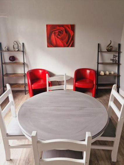 a dining room with a white table and red chairs at 3 Bedroom house, close to woodland, chesterfield and peak District in Brimington