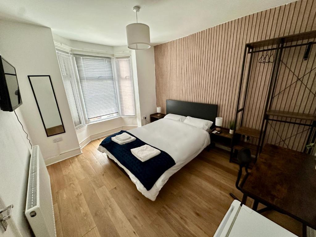 a bedroom with a large bed with two towels on it at Stratford Guesthouse in London