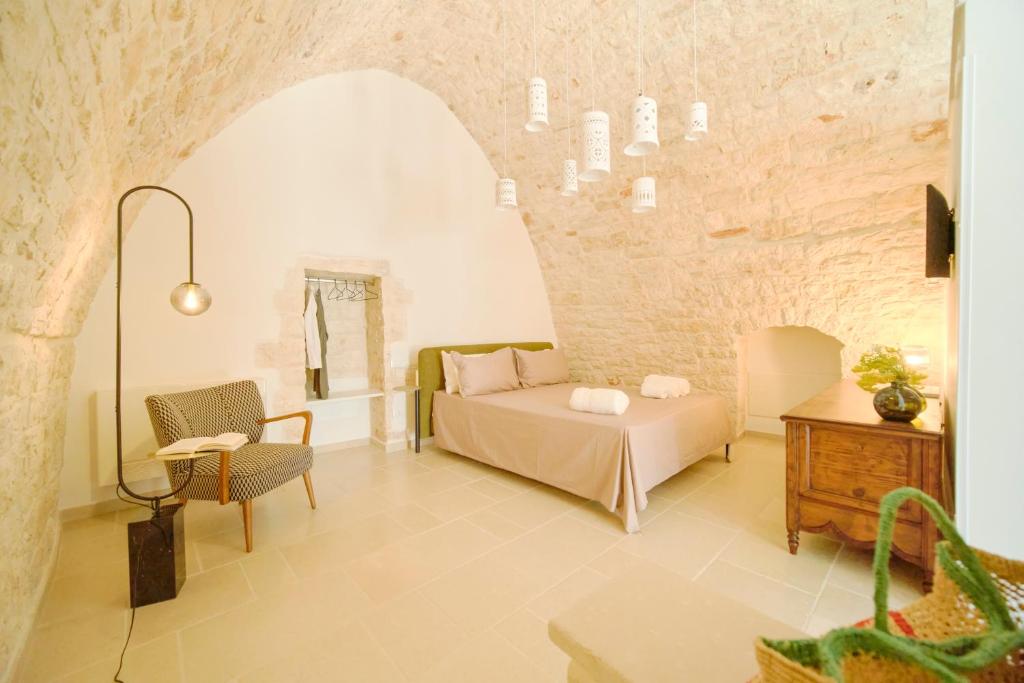 a bedroom with a bed and a table and a chair at Palazzo Gentile in Locorotondo