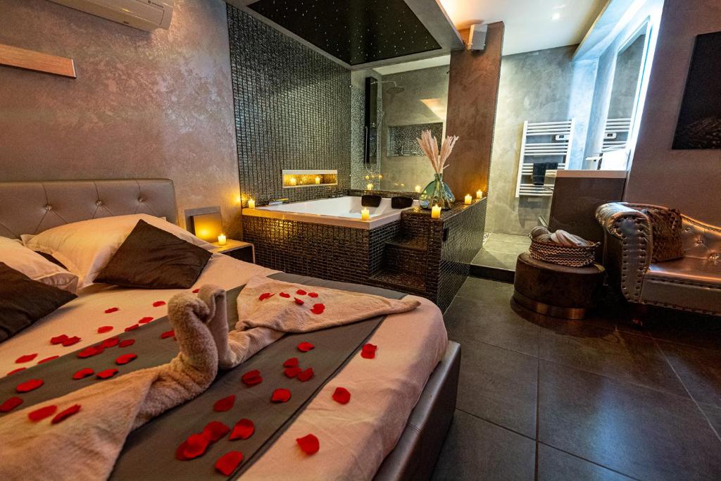 ナルボンヌにあるSuite Romantiqueのベッドルーム1室(バスタブ、赤い花のベッド1台付)
