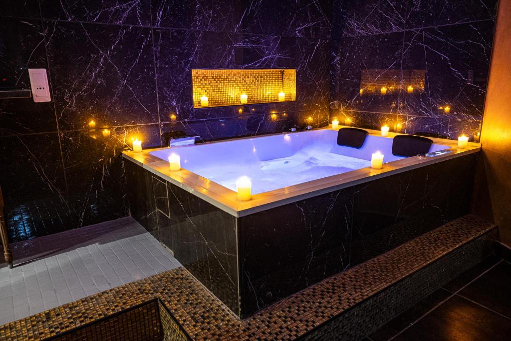 a bathroom with a tub with candles and lights at Suite Romantique in Narbonne