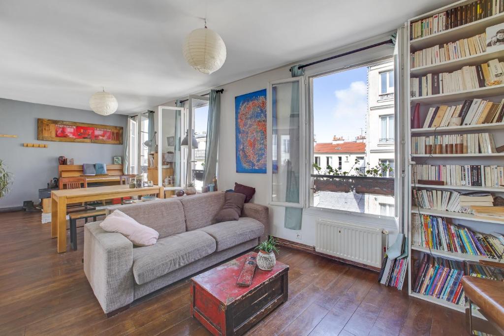 - un salon avec un canapé et quelques livres dans l'établissement SUPERBE DUPLEX avec JARDIN PARTAGE à PARIS MENILMONTANT, à Paris