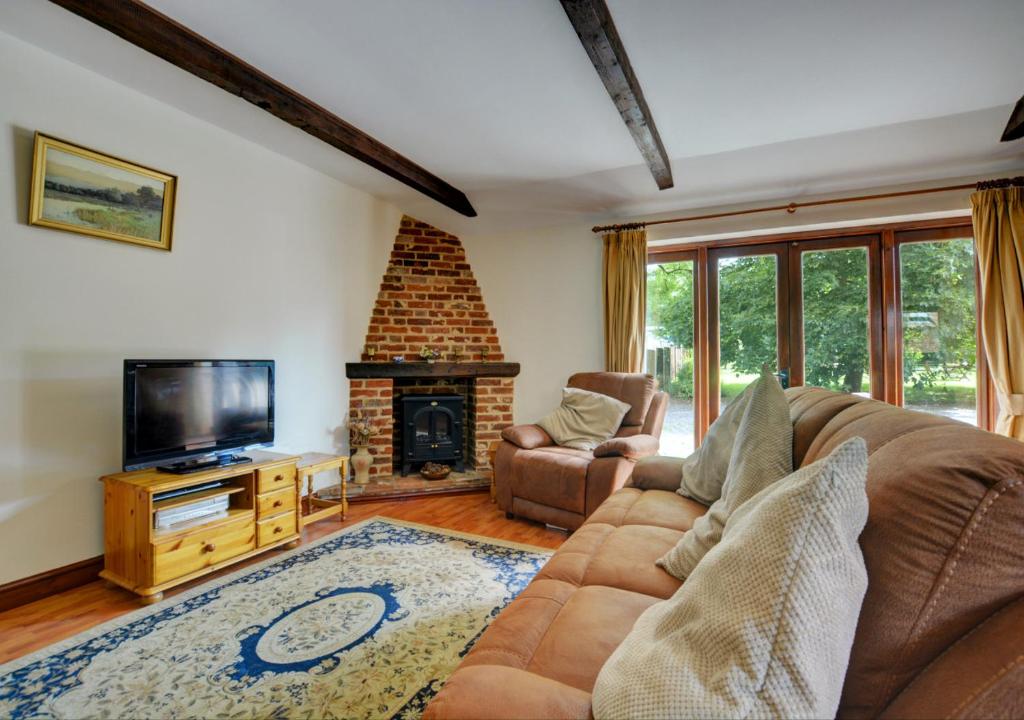 a living room with a couch and a fireplace at The Orchard in Lyng