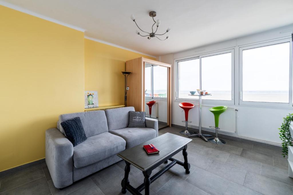a living room with a couch and a table at RDC FACE A LA MER in Dunkerque