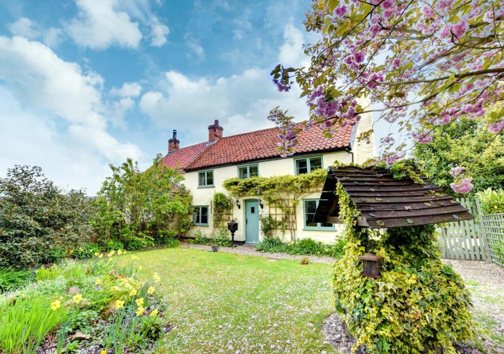 uma vista exterior de uma casa com um jardim em The Cottage em Scole