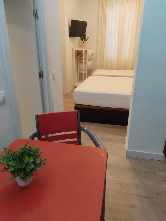 um quarto com uma cama e uma mesa e cadeira vermelhas em Grand Via House em Madri