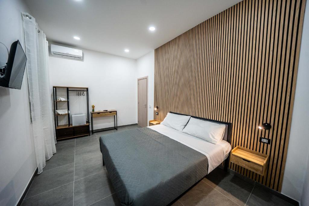 een slaapkamer met een bed en een houten wand bij Luna Marie in Palermo