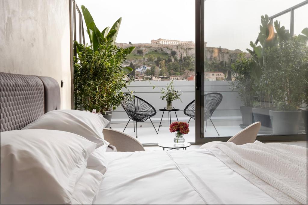 a bedroom with a bed and a balcony with plants at Regal Hotel Mitropoleos in Athens