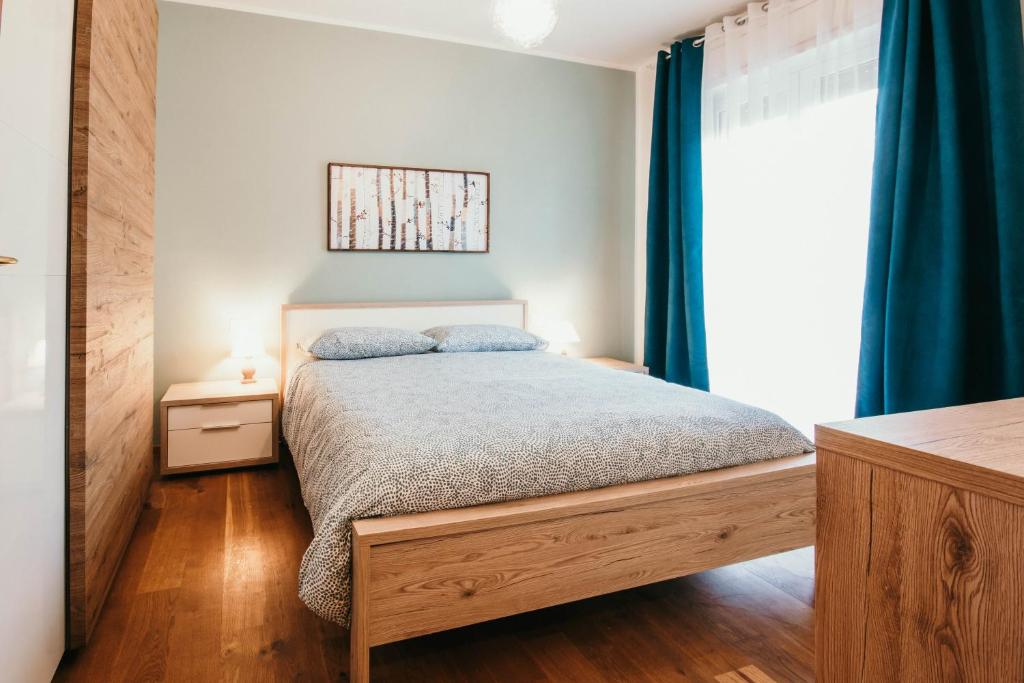 - une chambre avec un lit doté de rideaux bleus dans l'établissement Da Mario - Lakeside SRL Leisure & Business, à Arona