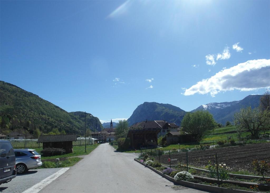 a road in a village with mountains in the background at Gästezimmer Casa Lundo 52 in Comano