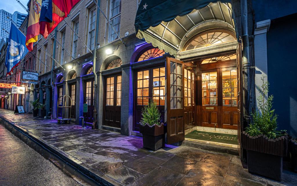a building with wooden doors on a street at night at Quarter House Suites in New Orleans