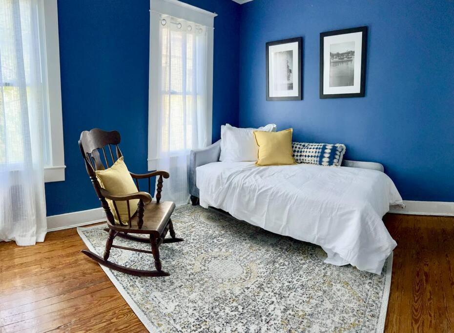 a blue bedroom with a bed and a rocking chair at Vintage Charm: Annapolis Retreat in Annapolis