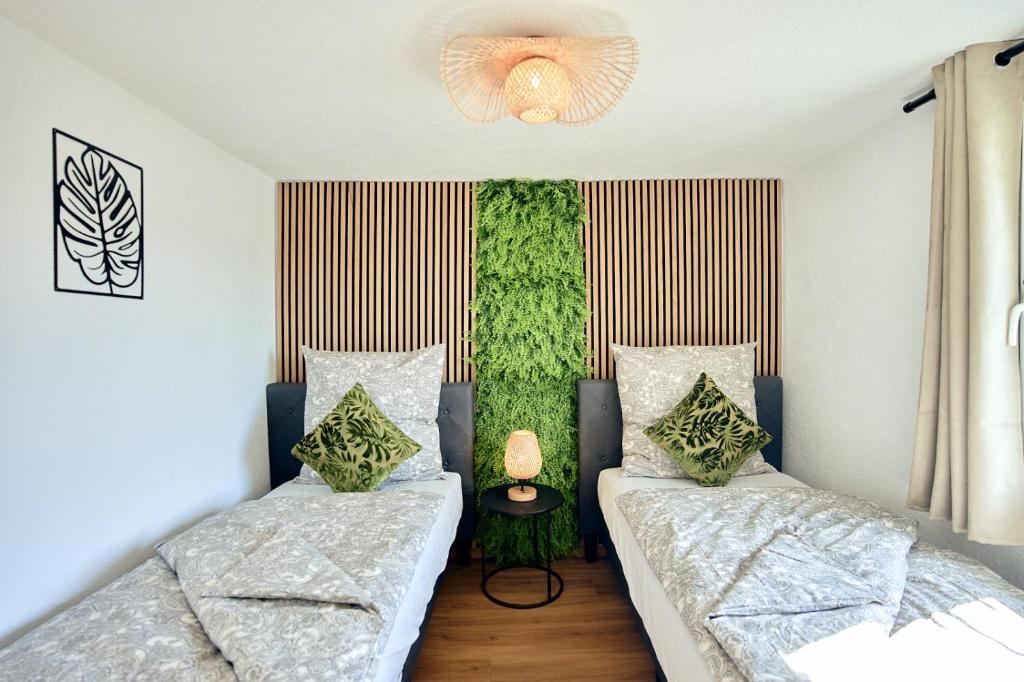 - une chambre avec 2 lits et un mur vert dans l'établissement LIVING Apartments / FeWo Neuwied, à Neuwied