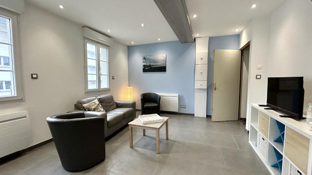 un salon avec un canapé et une télévision dans l'établissement Les bateaux, duplex 4 personnes proche plage, au Crotoy