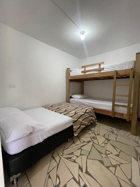 a bedroom with two bunk beds and a carpet at Ruta Jardín in Jardin