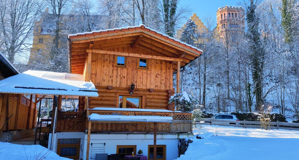 eine Blockhütte im Winter mit Schnee in der Unterkunft Schlossalm Ferienwohnungen in Brannenburg