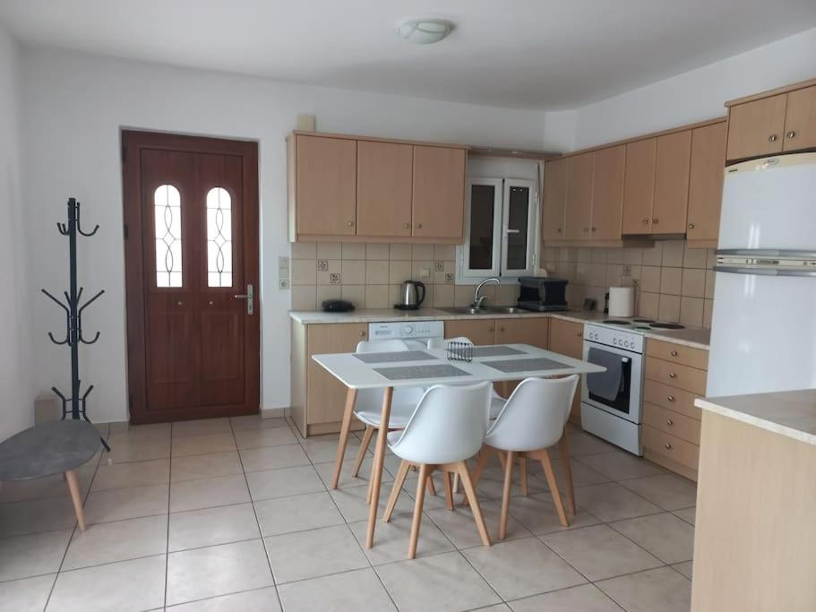 a kitchen with a table and some white appliances at Sophie's Sunny Spot 2 in Yéfira