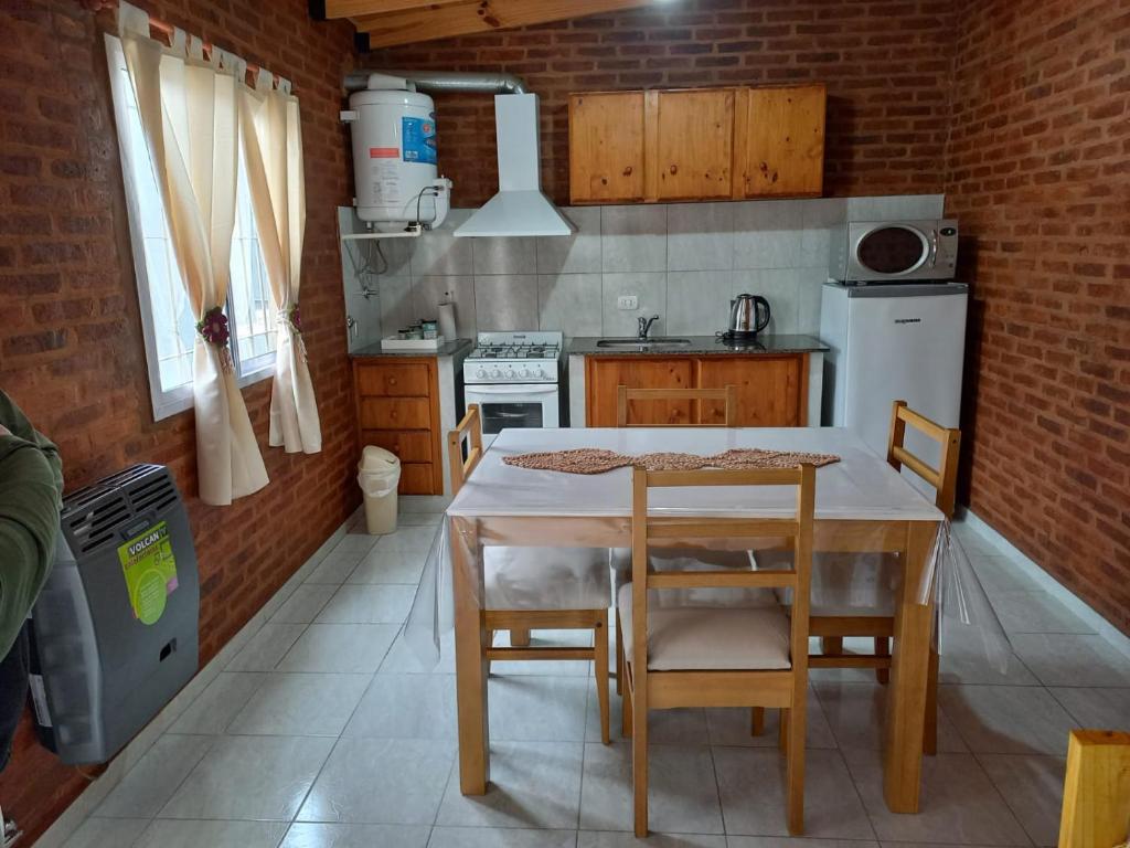 a kitchen with a table and chairs in a room at 4 Estaciones in Pergamino