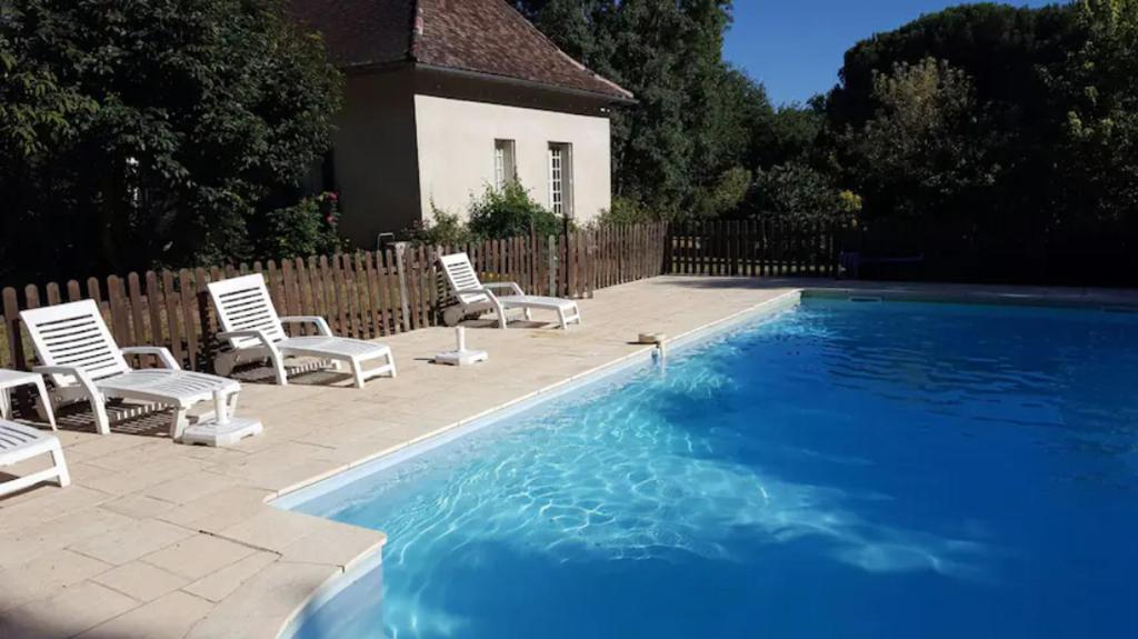 貝爾熱拉克的住宿－Le Chalet du Moulin Blanc，一个带椅子的游泳池以及一座房子